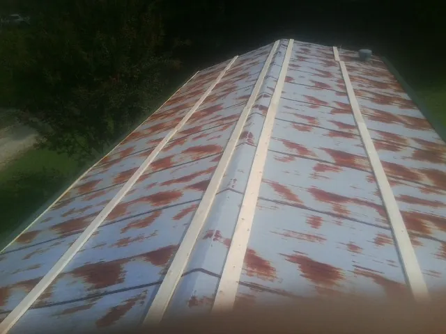 Rusted metal roof panels with new wood purlins before replacement — Storm Damage Roof Repair in Sneedville by Roofing Brothers