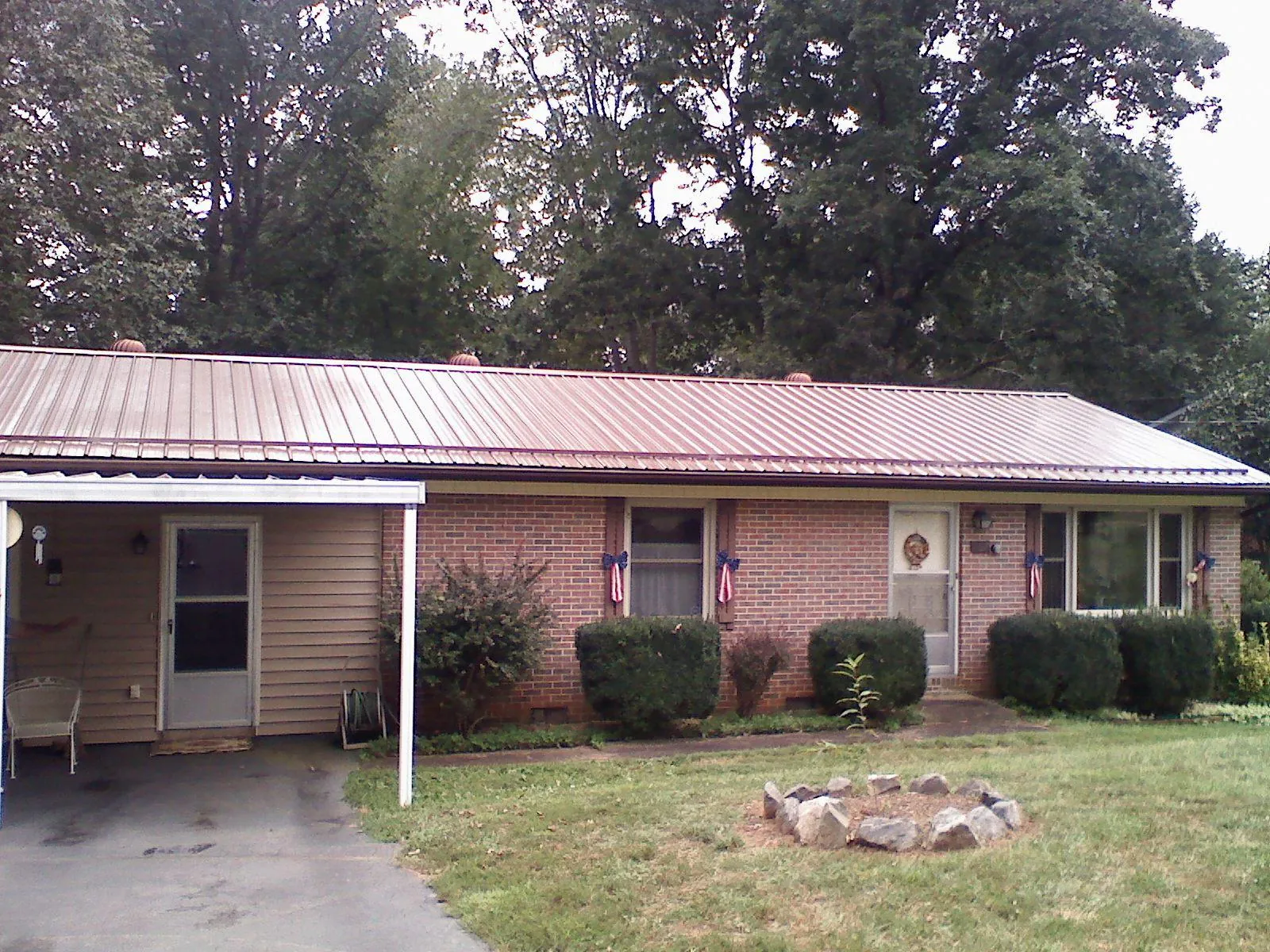 Bronze metal roof and carport on a brick ranch home — Roof Repair work by our crew in Sneedville